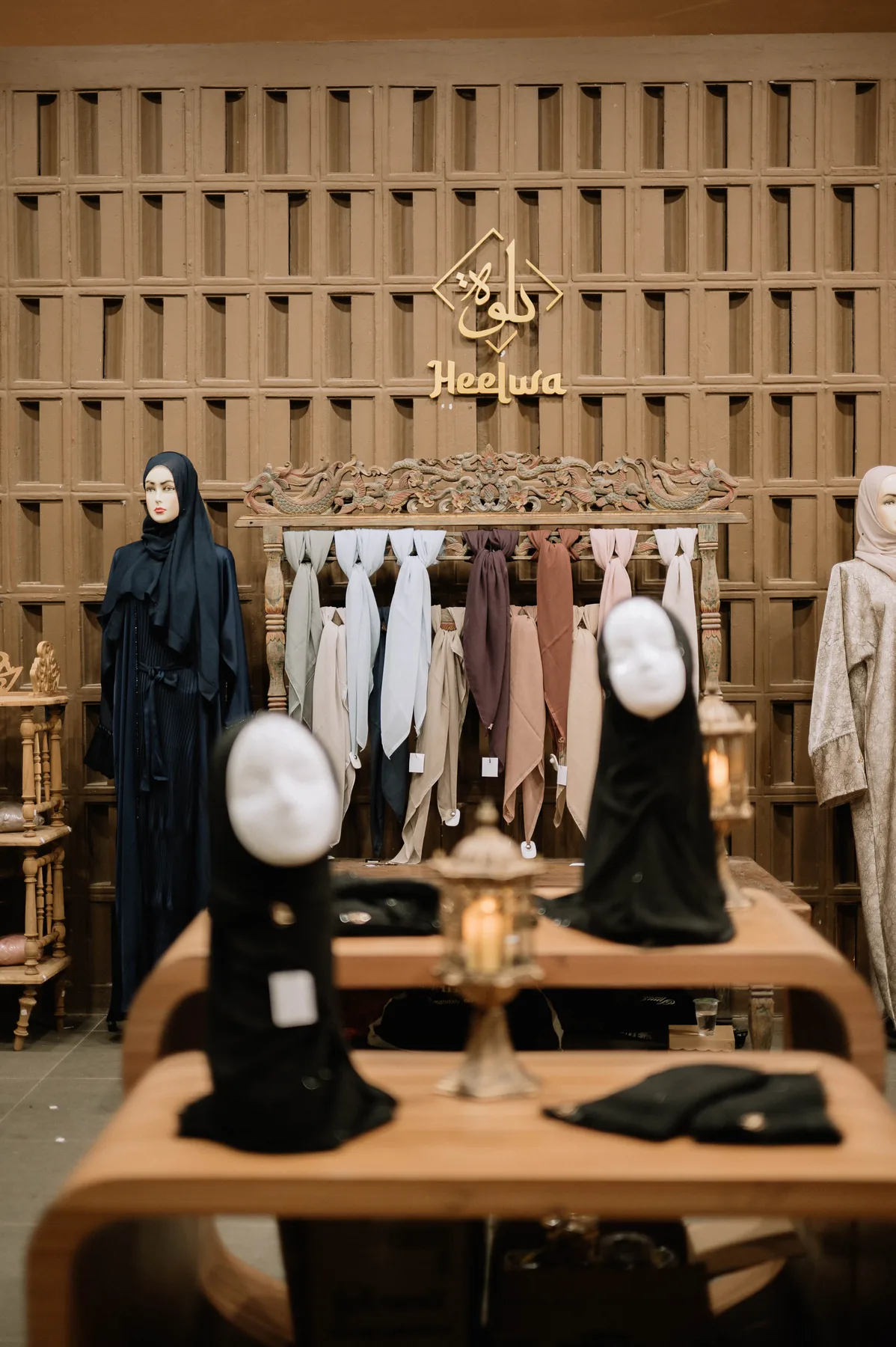 Display busana dan hijab dengan logo Heelwa serta manekin yang mengenakan koleksi
